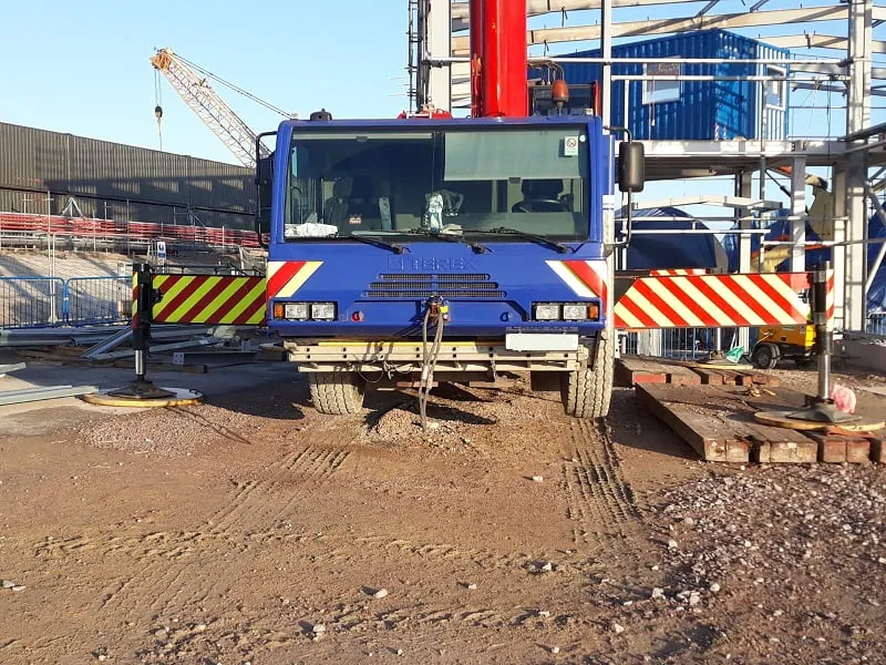 Grue mobile stabilisée et calée sur un chantier industriel